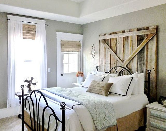 a welcoming farmhouse bedroom with wooden shades and a weathered wood headboard plus a metal bed