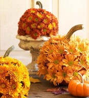 fall pumpkins covered with bright faux blooms are stylish fall decor and can be used both indoors and outdoors