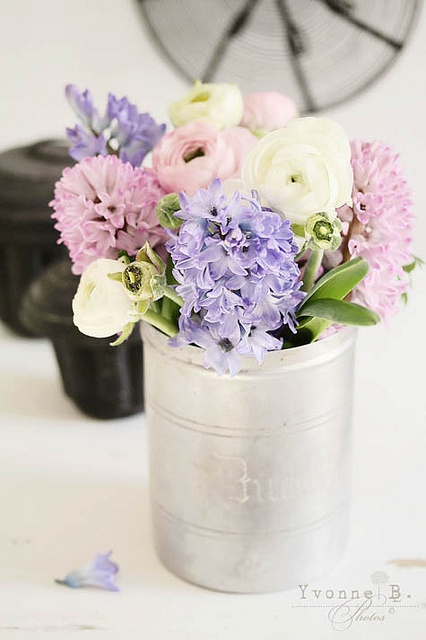 A tin can with pastel and white spring blooms is a beautiful and cool rustic arrangement for your spring infused space