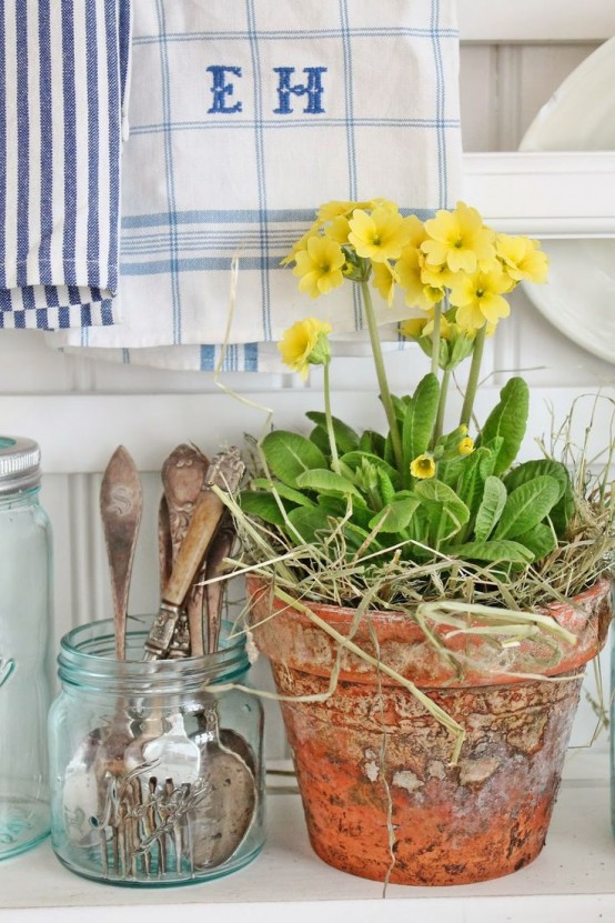 a terracotta planter with bold yellow blooms and hay is a lovely idea for a spring space and will add a rustic feel at the same time