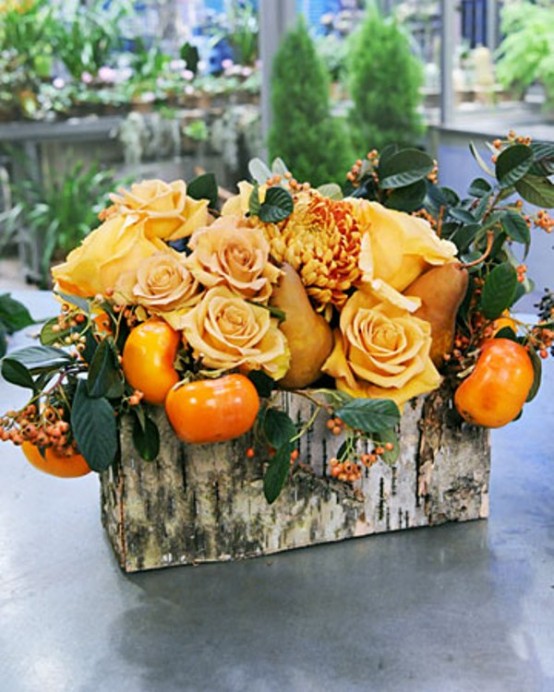 a bright fall or Thanksgiving centerpiece of a birch box, orange blooms and matching orange fruit and greenery is a cool idea for the fall