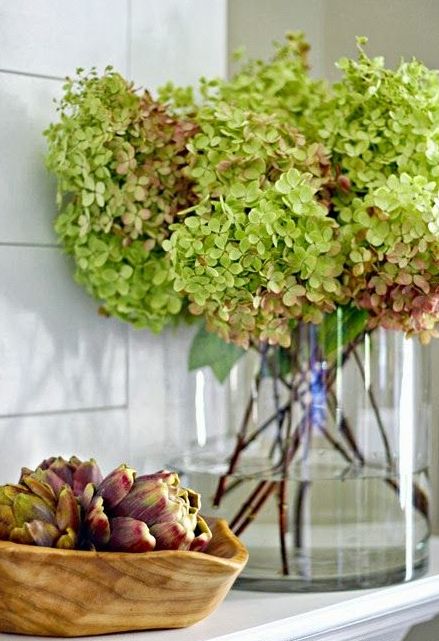 a large glass vase with green hydrangeas is a lovely and easy fall or Thanksgiving centerpiece to rock