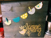 a rustic spring sign with a colorful banner and yellow calligraphy plus a bird is a lovely idea with a touch of fun