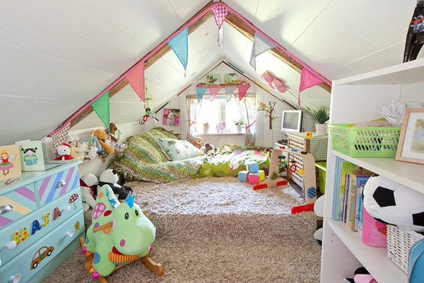 Afun and colorful attic kid's room with a large green bed, colorful buntings, a blue dresser and a storage unit with colorful decor