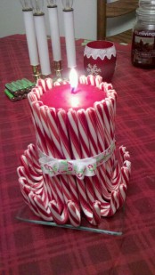 a red candle wrapped with candy candes is an easy and fun decoration you can easily make your space and it looks whimsical