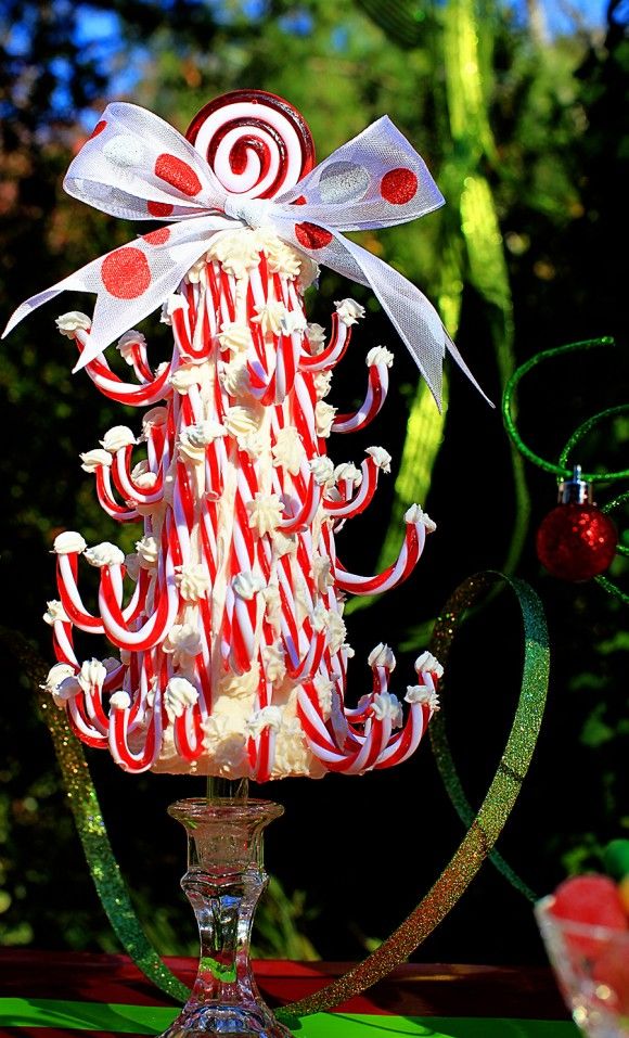 A bright and creative Christmas tree made of candy canes, meringues and with a bow can be eaten as a dessert when you get tired of its look