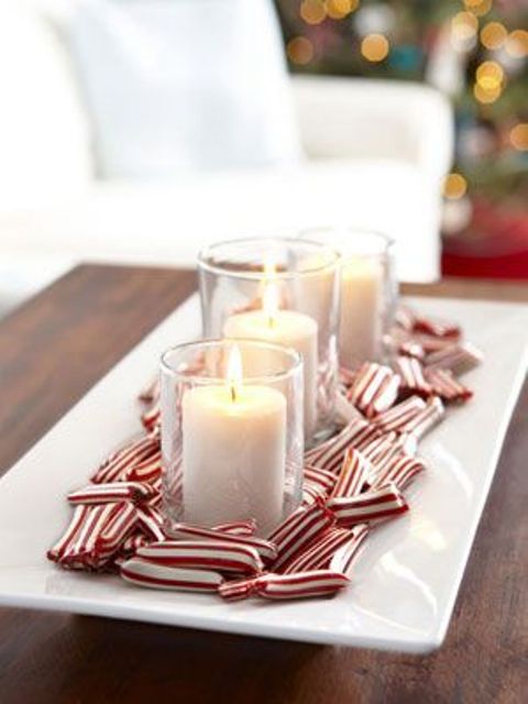 a Christmas centerpiece of a square dish with candles and candy canes on it is a lovely and easy decor idea to recreate