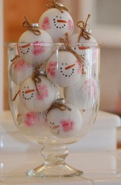 a tall bowl with snowman heads that are ornaments – decorate your Christmas tree with them to make the tree look amazing