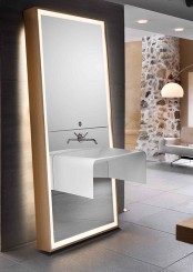 a large lit up floor mirror that holds a sink is a lovely idea for a contemporary bathroom, it’s a very smart and sleek solution