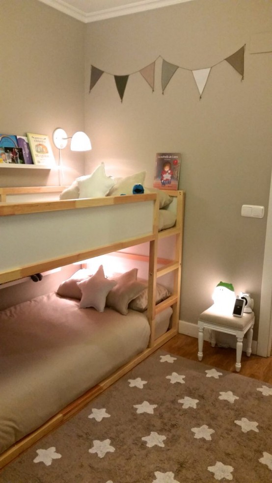 aneutral wooden bunk bed unit with wall lamps and a ladder attached for a natural touch in the room