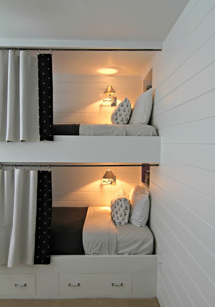 Contemporary built in bunk beds with storage drawers, curtains and wall lamps to make the spaces cozier