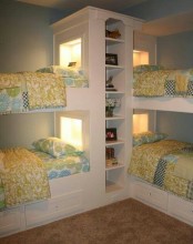 a unk bed unit for four with a built-in storage unit and built-in lights plus storage drawers in the lower beds