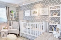 a gender neutral nursery with an accent wallpaper wall, white furniture, lights and white and neutral toys