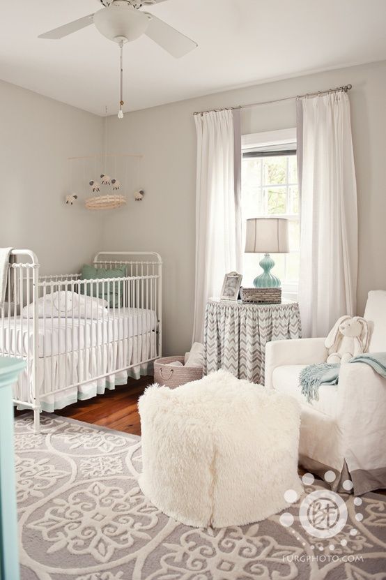 a neutral farmhouse nursery with grey walls, vintage furniture, white and printed textiles and touches of mint blue