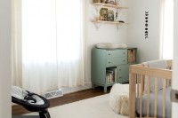 a neutral farmhouse nursery with light-colored furniture, a green changing table, neutral textiles is a very cozy and welcoming room