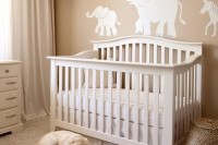 a gender neutral nursery with tan walls and elegant white furniture, faux fur and a pendant lamp is very welcoming