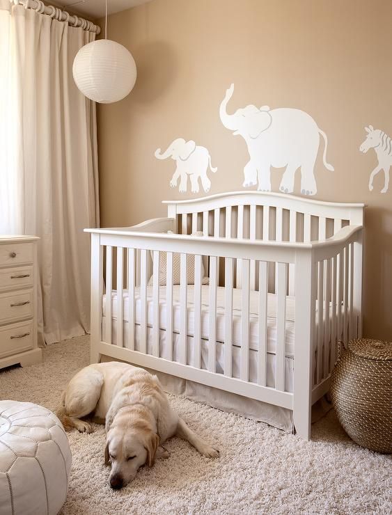 a gender neutral nursery with tan walls and elegant white furniture, faux fur and a pendant lamp is very welcoming