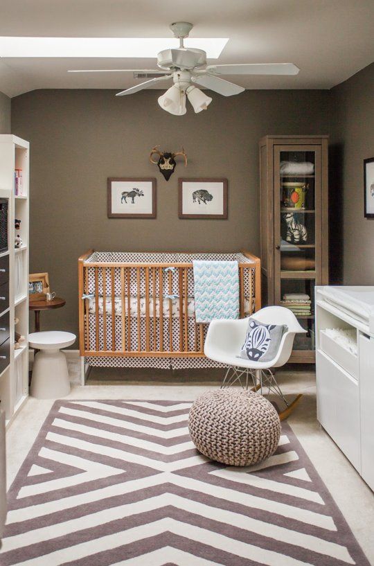 A gender neutral nursery with taupe walls, white and neutral furniture, printed textiles and a skylight on the ceiling