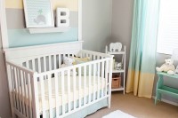 a colorful gender neutral nursery with striped walls and color block curtains, with white and mint furniture and some art