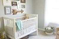a neutral and welcoming nursery with grey walls, grey and white furniture, a gallery wall and some toys that match