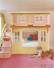 a colorful girl’s room with a unique house-shaped bed with a storage ladder, colorful pillows and toys is a fun and cute space