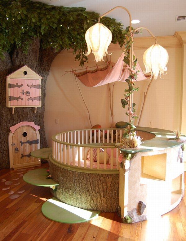 A fairy tale girl's room with a tree with pink doors, a round kid bed with pink bedding, whimsical flower shaped lamps and some rugs