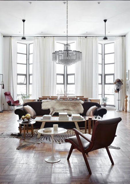 The glam art deco living room can boast of a Swarovski crystal chandelier, floor-to-ceilings windows that let in light and fur furniture covers for a glam touch