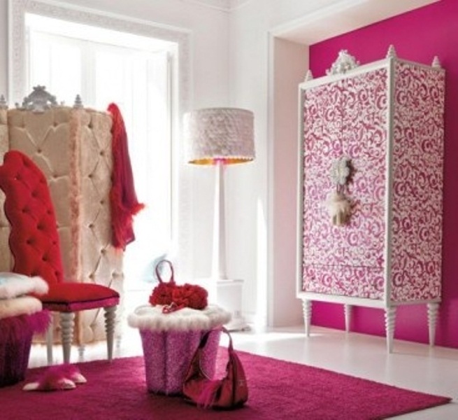 A pink, red and white glam bedroom with a printed wardrobe, a refined screen, a red chair and a pink rug on the floor