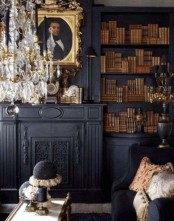 a refined Gothic library in black, with built-in shelves, a faux fireplace, a crystal chandelier, refined artworks and a low table plus a black sofa