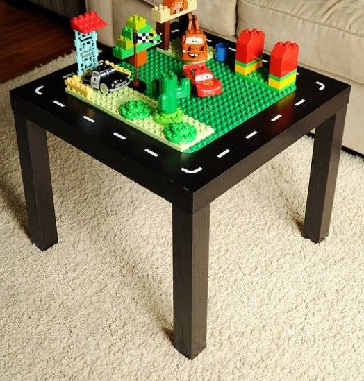 An IKEA Lack table turned into a kids' playtable   it's painted black and on top you may see a surface for playing LEGO