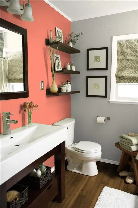 a modern meets rustic bathroom done in coral and grey, with dark stained wooden furniture and white appliances