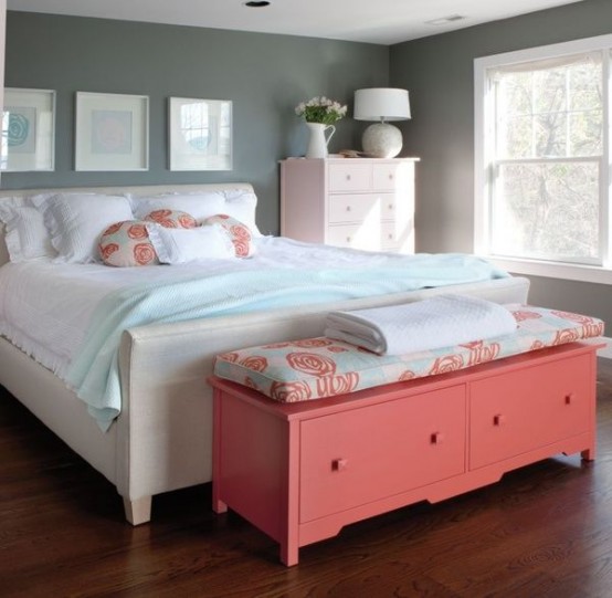a welcoming bedroom with grey walls, white furniture, a gallery wall, a coral storage bench