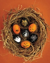 a nest with eggs that are painted as scary Halloween pumpkins is a very creative decoration for Halloween