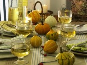 all-natural pumpkins and gourds echo with plates and glasses and give a cozy natural look to the tablescape