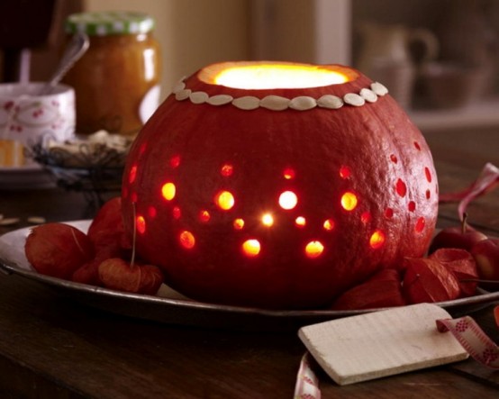 a perforated pumpkin with candles inside is a cool fall or Thanksgiving decoration or a centerpiece to rock