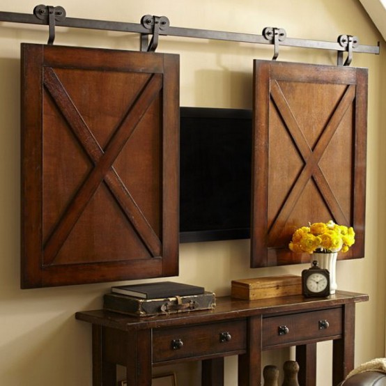 a TV hidden behind barn doors that fit in size is a cool idea for a rustic or farmhouse interior