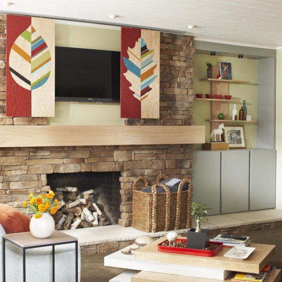 a fireplace clad with stone and with a TV over the fireplace plus bold leaf panels to hide the TV