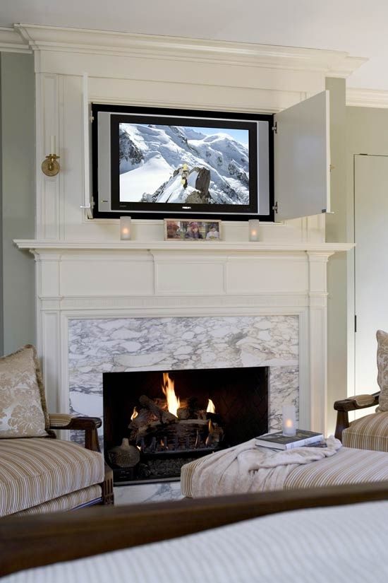 a white stone clad fireplace wiht a neutral mantel, a TV hidden with doors are a chic and cool combo for a modern space