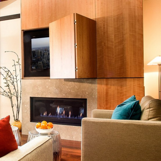 a TV placed over a fireplace and clad and hidden with a folding wooden panel are a cool combo for a modern interior