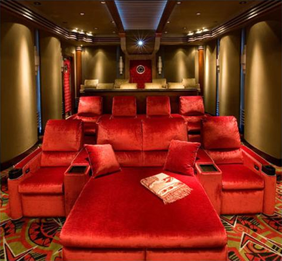 An elegant home theater with mustard walls, hot red seating furniture, built in lights is a chic and cool space