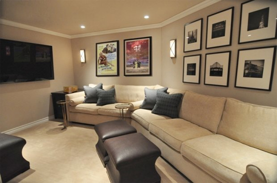 a neutral living room with a screen, a neutral sofa, gallery walls, dark stools and poufs is a pretty space to enjoy a film