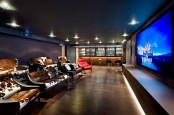 a gorgeous home theater with a large screen, built-in lights, sofas and chairs with cowhide covers, a home bar on one side is an amazing space to spend time