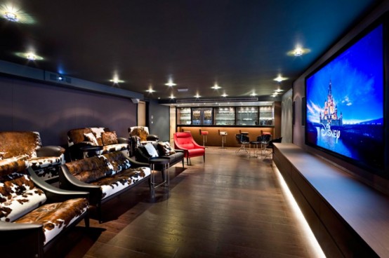 a gorgeous home theater with a large screen, built-in lights, sofas and chairs with cowhide covers, a home bar on one side is an amazing space to spend time