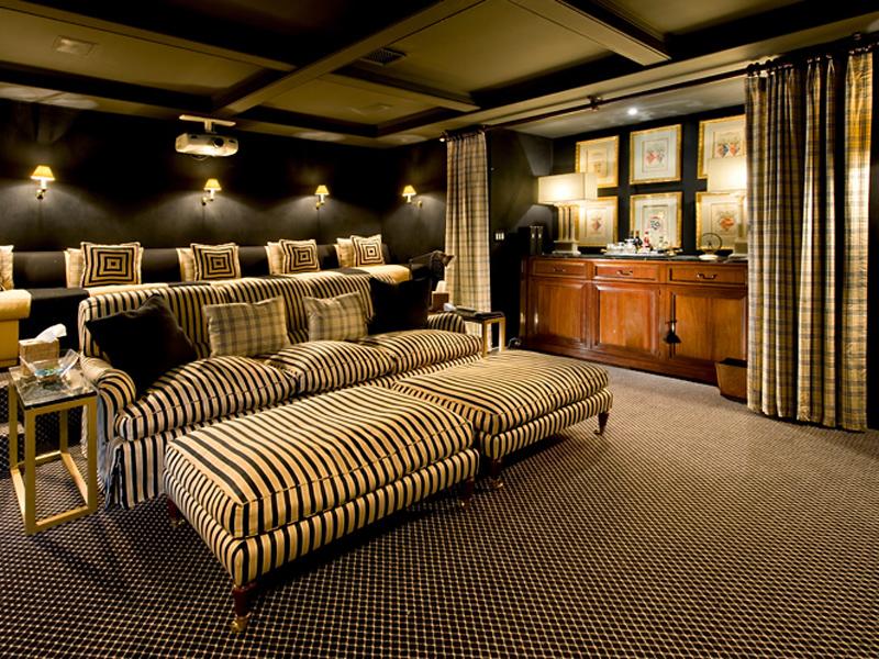 a chic and catchy home theater with black walls, a black sofa and striped sofas and chairs, a small home bar that can be hidden with curtains