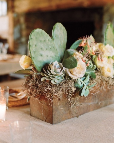 A rusty tin planter with succulents, cacti, moss and hay can be used as a pretty and chic centerpiece with a desert feel