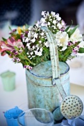 a vintage blue watering can with some wildflowers can be a nice decoration or centerpiece for any occasion