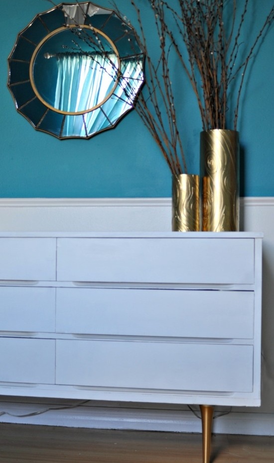 an IKEA Malm dresser hack with tall metal legs and shiny contact paper in between the drawers