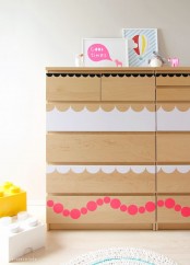 a light-stained IKEA Malm dresser hacked with simple white and pink decals on the drawers