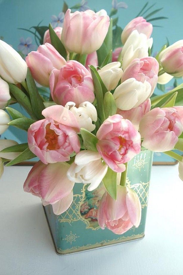 A light blue vintage tea can with pink and white tulips is a pretty vintage inspired centerpiece