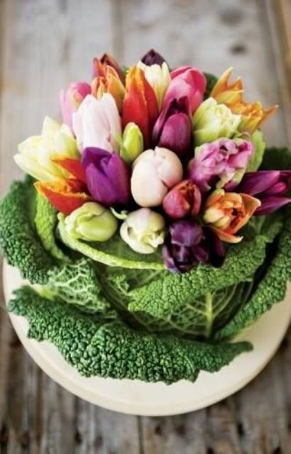 Place colorful tulips into a cabbage instead of a usual vase to compose a cute rustic inspired centerpiece